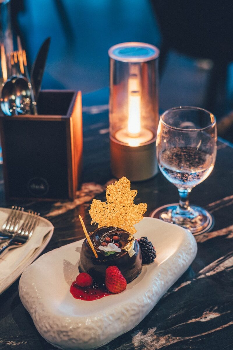 Chocolate dessert with berries and gold leaf garnish
